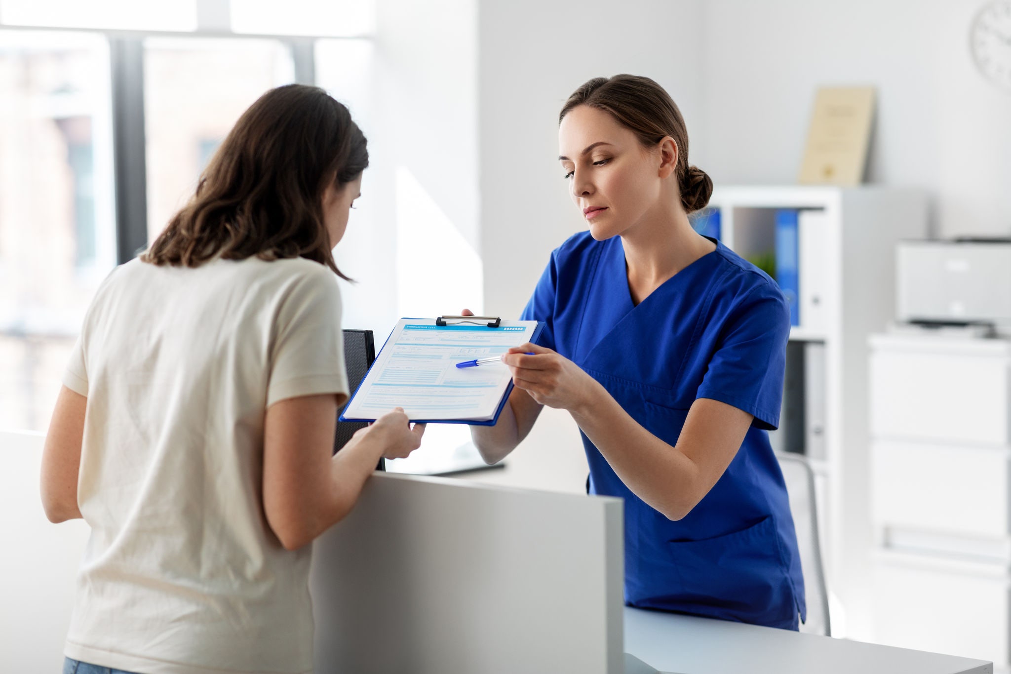 medicine, people and healthcare concept - female doctor or nurse with clipboard and patient at hospital