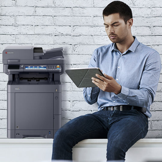 man working with a printer and tablet