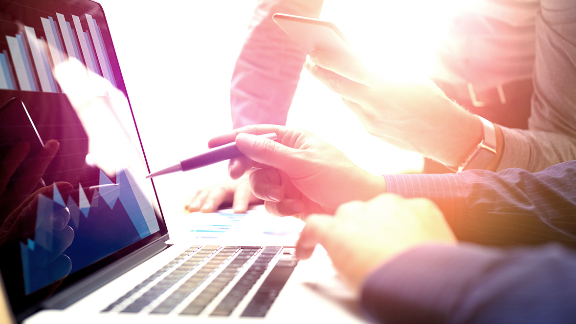 close up of colleagues looking at a laptop