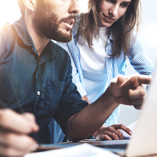 man pointing at laptop screen