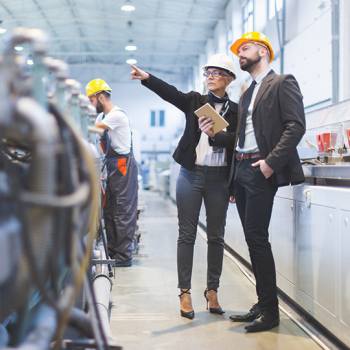 Perché diminuire la carta? businessman and woman wearing hard hats on site