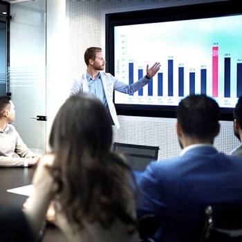 Il digitale ridisegna i modelli aziendali man presenting graph to a meeting