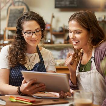 Come ottimizzare i cicli di vendita workers in overalls looking at tablet