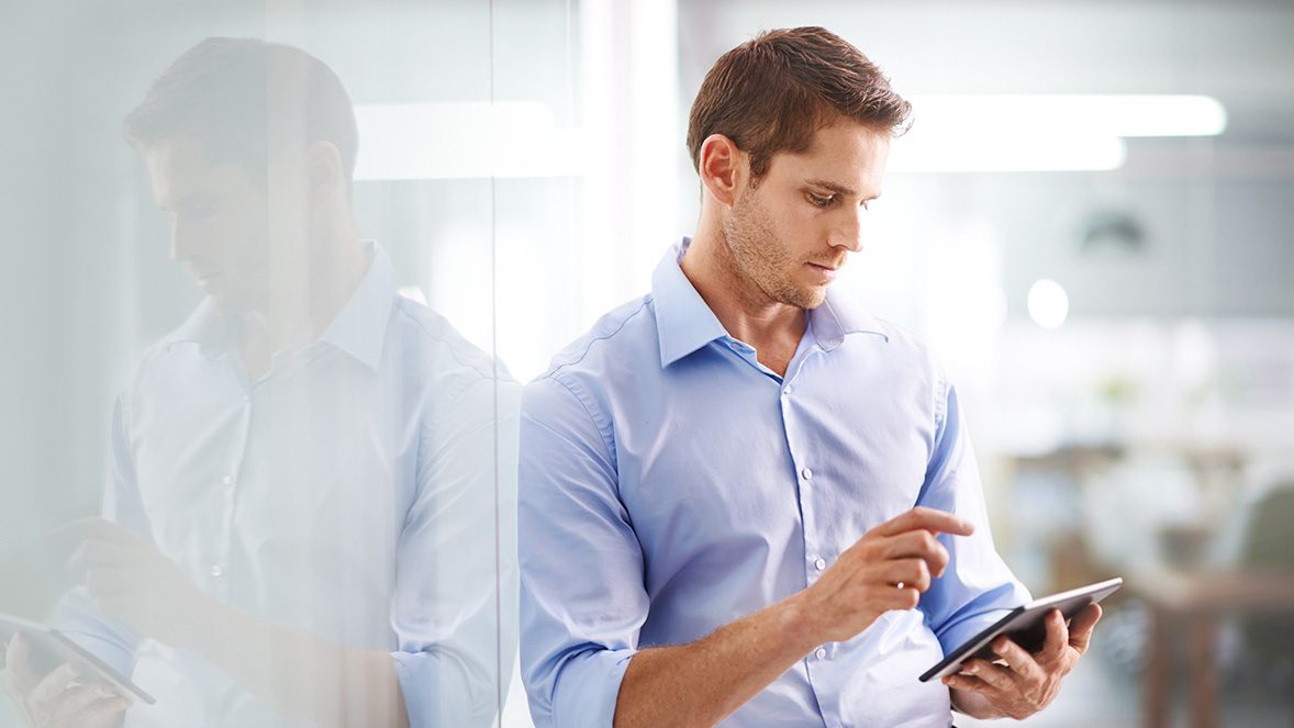 man standing by wall using tablet man standing by wall using tablet