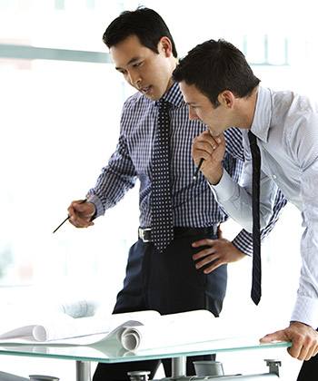 Informazioni ricercabili semplicemente two businessman standing over and studying some forms