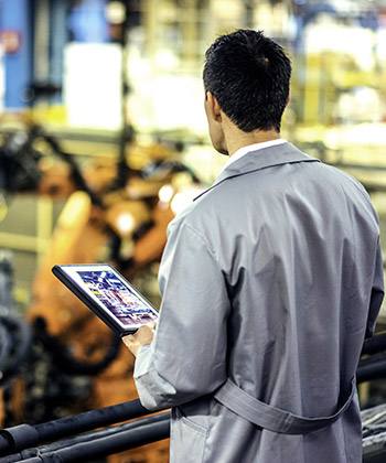 Semplificare le catene di approvvigionamento  man surveying a workspace and holding a tablet