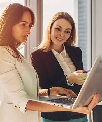 Integrare con i sistemi esistenti two colleagues working on laptop