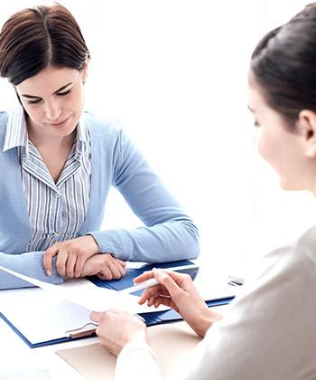 Facilitare la conformità two women in a meeting